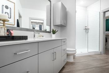 a bathroom with white cabinets and a white toilet